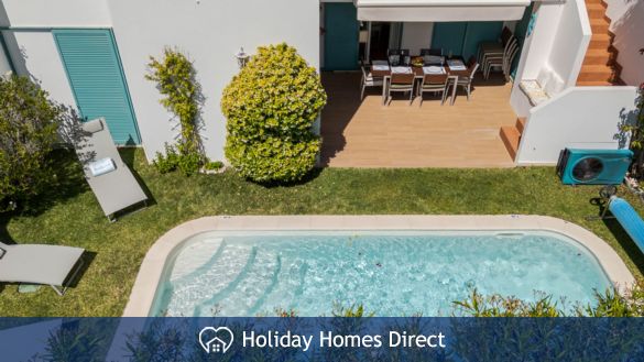 pool view sorrounded  by green & relax sunbeds